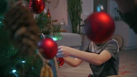 Boy-wears-Christmas-toys-for-Christmas-tree.-High-quality-4k-footage